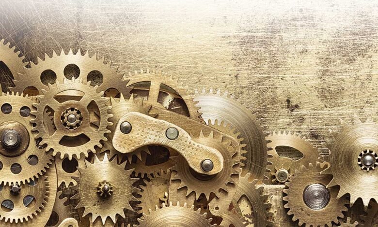 Close-up of interlocking golden gears and cogs on a textured background.