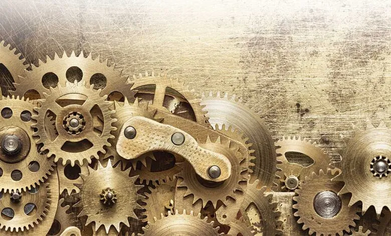 Close-up of interlocking golden gears and cogs on a textured background.