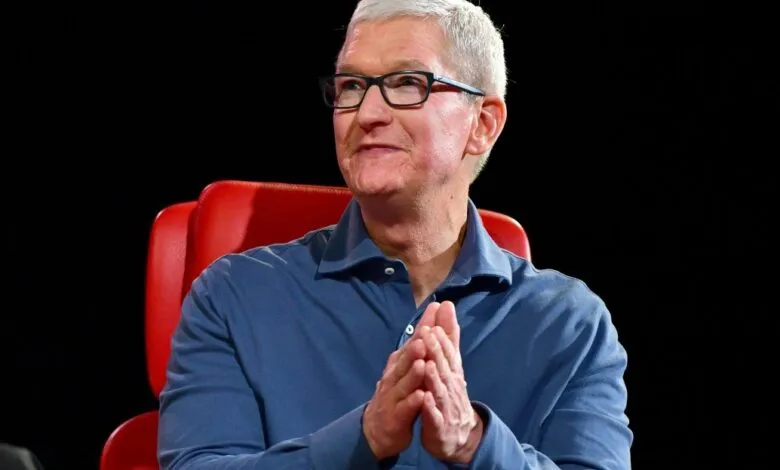 Tim Cook, Apple CEO, sits in a red chair with hands clasped.