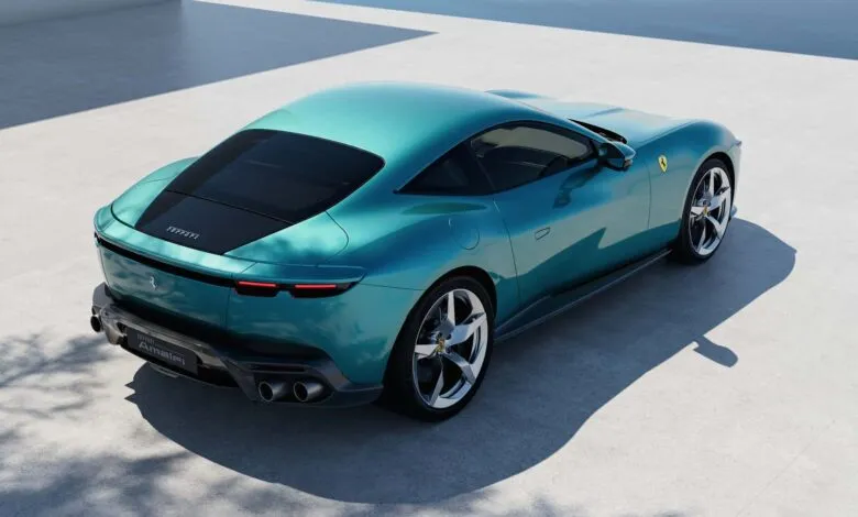 Rear view of a teal Ferrari Amalfi sports car parked on a light gray surface.