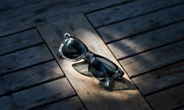 Clear Ray-Ban sunglasses rest on a weathered wooden surface.