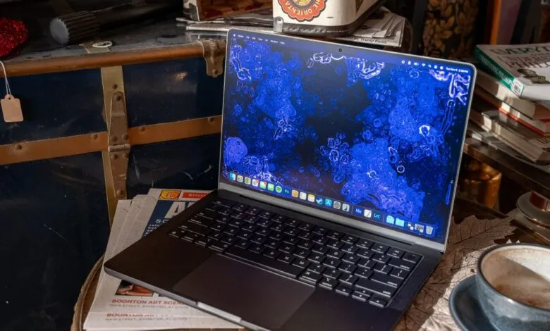 Open MacBook Pro on a desk with a blue abstract wallpaper.