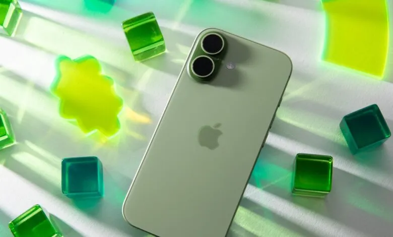 Green iPhone with dual cameras surrounded by green and yellow translucent shapes.