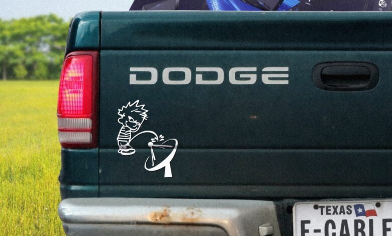 Dark green Dodge truck tailgate with Calvin and Hobbes sticker.