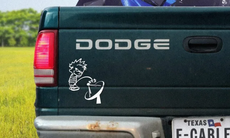 Dark green Dodge truck tailgate with Calvin and Hobbes sticker.