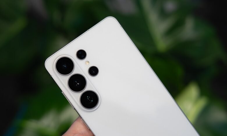 Close-up of a white smartphone with multiple camera lenses on the back.