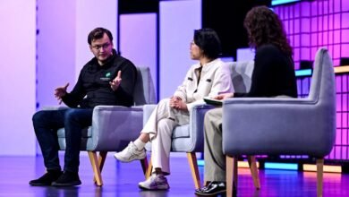 Panel discussion with three people seated on stage in armchairs.