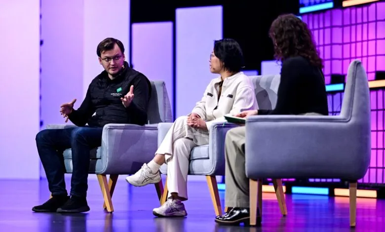 Panel discussion with three people seated on stage in armchairs.