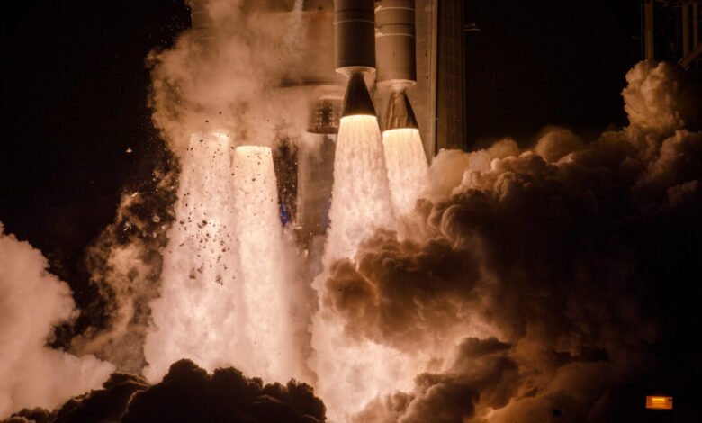 Rocket launch with bright flames and billowing smoke against a dark sky.