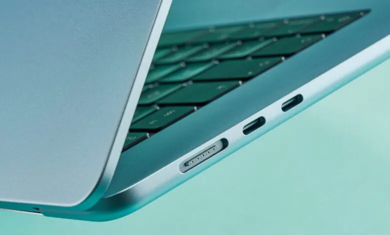 Close-up of a blue Apple MacBook Air showing ports and keyboard.