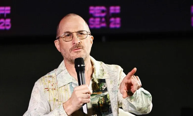 Darren Aronofsky speaking into a microphone at an event.