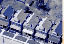 Aerial view of a row of similar two-story houses with front porches and small yards.