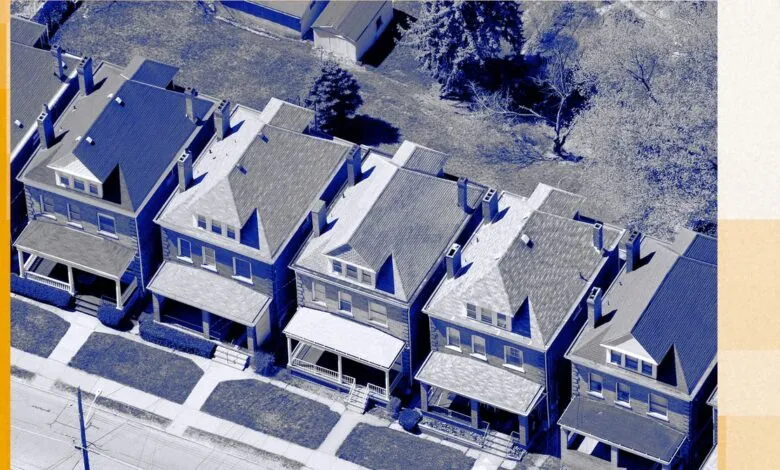 Aerial view of a row of similar two-story houses with front porches and small yards.