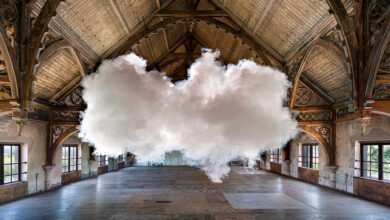 Large cloud formation indoors in a grand, decaying hall with arched ceiling.