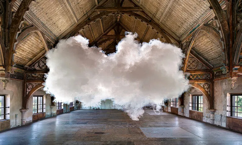 Large cloud formation indoors in a grand, decaying hall with arched ceiling.