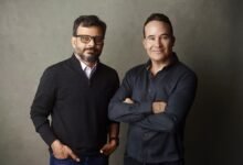 Two men, Tom Chavez and Vivek Vaidya, stand side-by-side in a studio portrait.