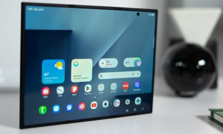 Foldable tablet displaying home screen with weather and app icons.