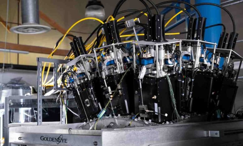 Complex machinery with black boxes, silver components, and colorful wiring.