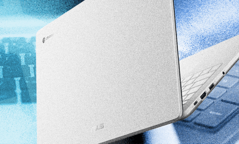 White Chromebook laptop, partially open, against a blue keyboard background.