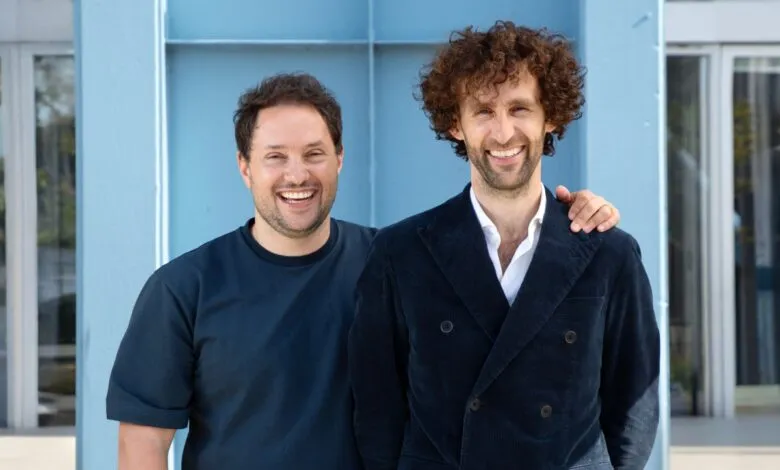 Two smiling men, David Schreiber and Duco Van Lanschot, pose together outdoors.