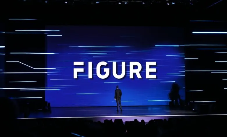 Speaker stands on stage in front of large screen displaying 'FIGURE'.