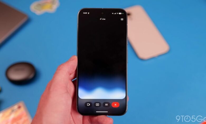 Hand holding phone displaying 'Live' recording interface on blue surface.