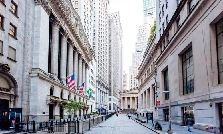Street view of the New York Stock Exchange with flags displayed.