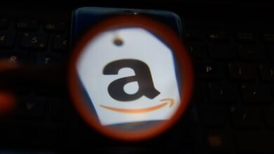 Amazon logo on a tag, displayed on a smartphone screen over a laptop keyboard.