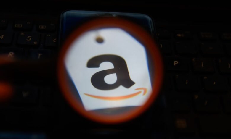 Amazon logo on a tag, displayed on a smartphone screen over a laptop keyboard.