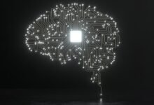 Brain-shaped circuit board with glowing chip in center on dark background.