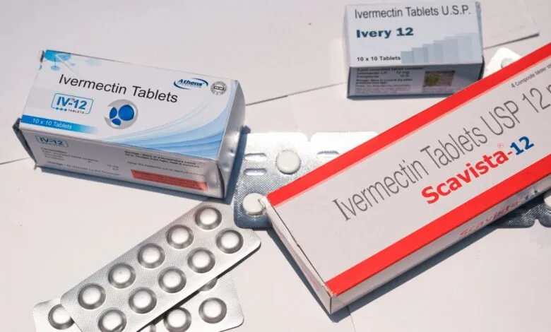 Boxes and blister packs of Ivermectin tablets on a white surface.