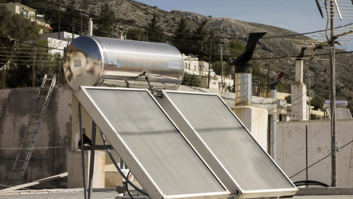 Solar water heater system on rooftop in Greek village.