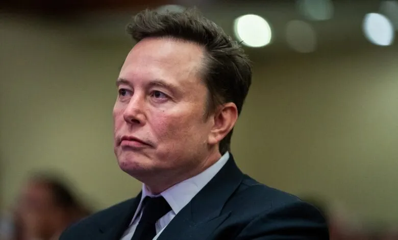 Close-up of Elon Musk in a suit, looking off to the side.