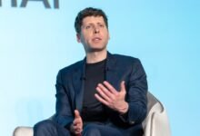 Sam Altman speaks at an event, wearing a suit and gesturing.