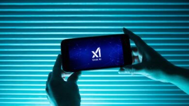 Hands hold phone displaying Grok AI logo against blue striped background.