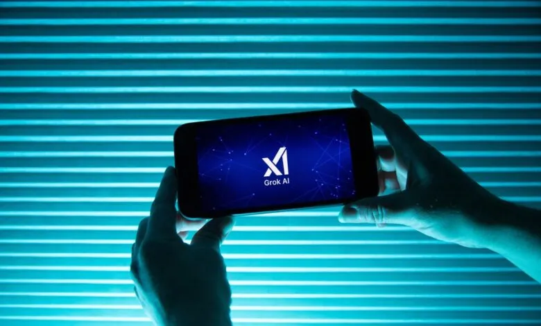 Hands hold phone displaying Grok AI logo against blue striped background.