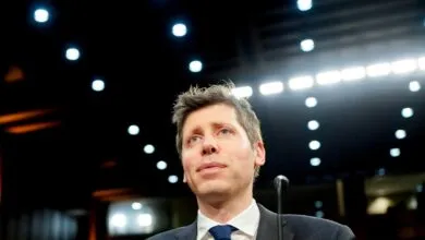Man in suit and tie looks upward in a brightly lit room.