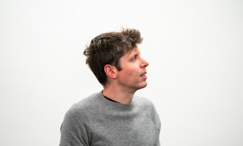 Man in gray sweater looking up against a white background.