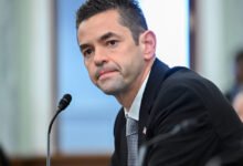 Jared Isaacman at Senate hearing, wearing suit and tie, microphone visible.
