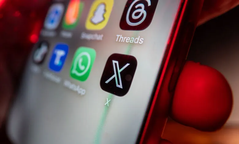 Smartphone screen displaying the new X logo among other app icons.