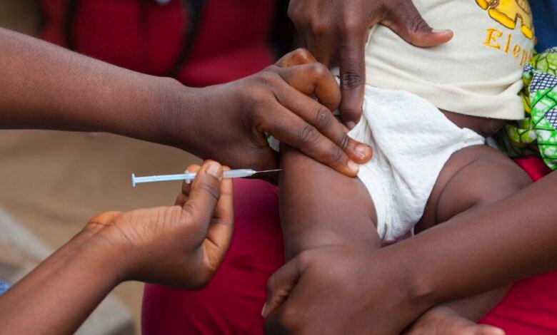 Close-up of a baby receiving a vaccination in the thigh.