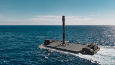 SpaceX Falcon 9 rocket booster on drone ship in the ocean.