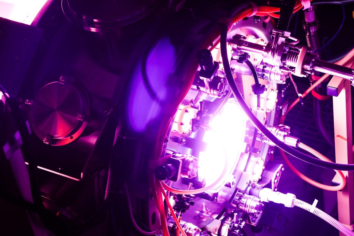 Fusion reactor with bright plasma glow, complex machinery visible.