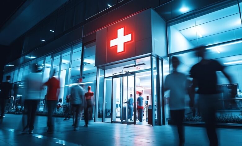 Modern hospital entrance with blurred figures and a glowing red cross.