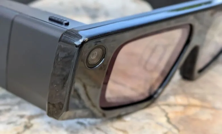 Close-up of black AR glasses with a camera on the frame.
