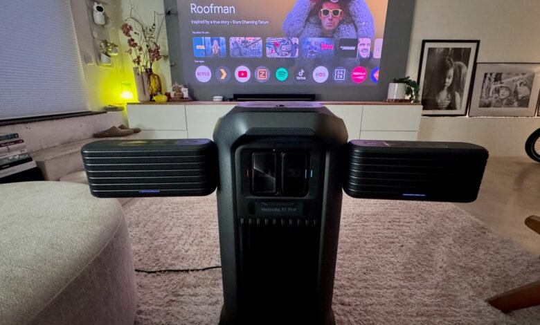 Nebula X1 Pro projector with speakers in a cozy living room setting.