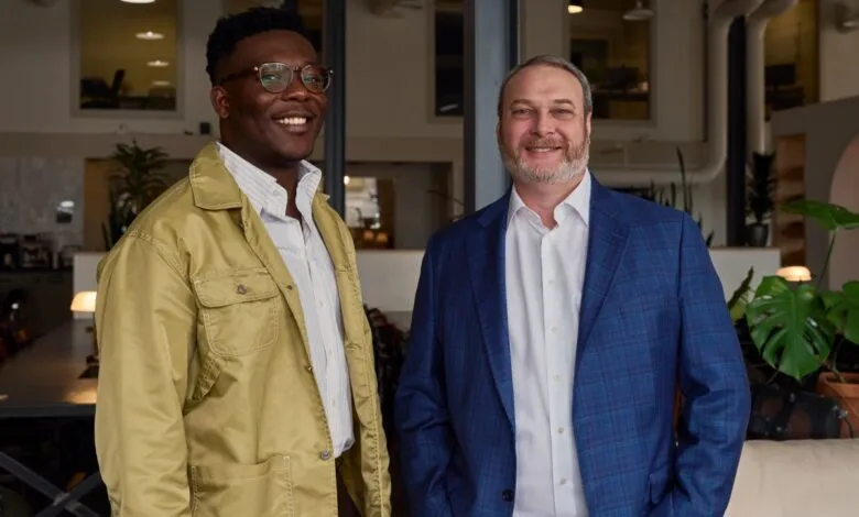 Two men, Joseph Akintolayo and Chris Heckler, smiling indoors.