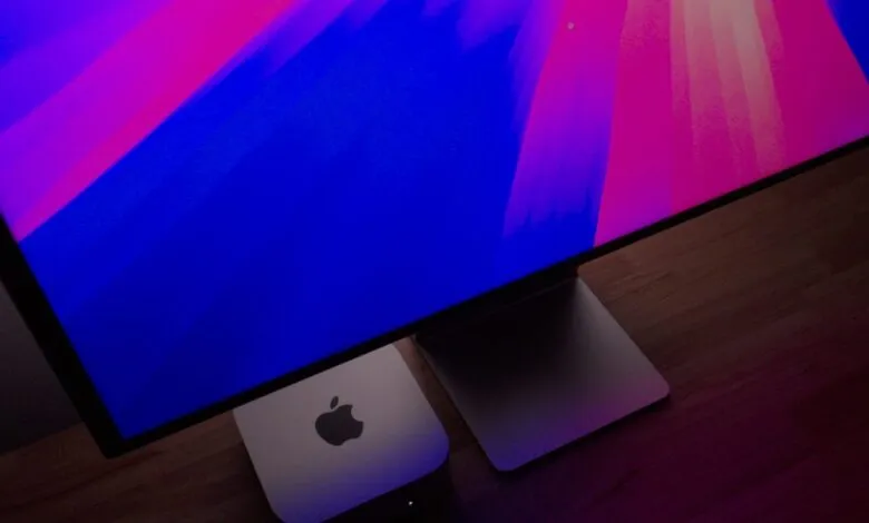 Apple Studio Display with vibrant blue and pink wallpaper, paired with a Mac Mini.