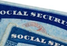 Close-up of two Social Security cards with blue text and decorative borders.