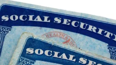 Close-up of two Social Security cards with blue text and decorative borders.